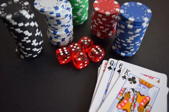 Żetony pokerowe i karty na ciemnym stole